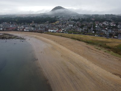 North Berwick beach with town and law/hill in background. there is a rain cloud around the hill.