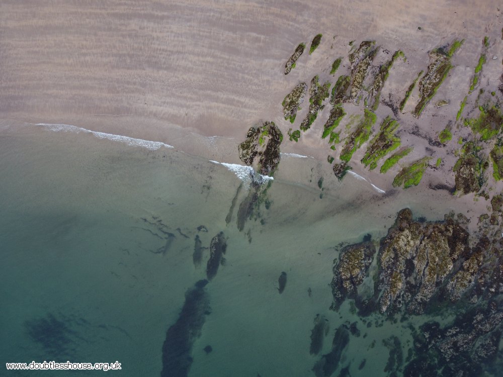 beach seen from above, sand, rocks and water